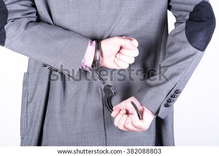 a picture of a businessman locked in handcuffs