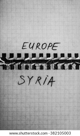 Sign of border and barbed wire fence between words - europa and refugees from syria