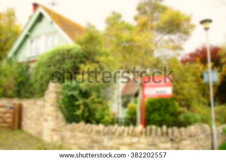 The blurry photo of house selling advertising signage represent the house selling business and real estate concept related idea.  