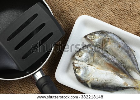 The short bodied mackerel fish put on the food grade foam tray among sack background in the scene appear the pan also represent the fish and seafood concept related idea.