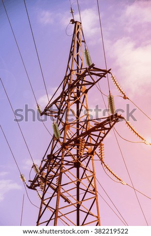 electricity transmission pylon silhouetted against blue sky at dusk
