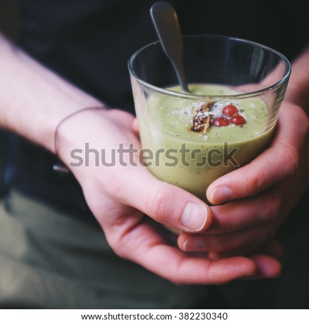 a man holding his mixed avocado, kiwi, grape and lemon green smoothie glass.  Royalty-Free Stock Photo #382230340