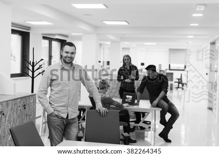 portrait of young business man in casual clothes sitting on table at  new startup office space and working on tablet computer