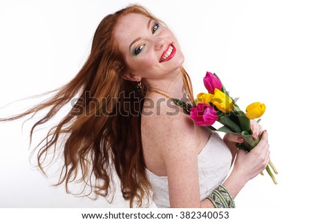 Girl with flying hair is holding colorful tulips