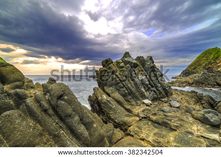 Natural rock with strong water wave and cloudy sunset background at Pantai Semeti Lombok, Indonesia
