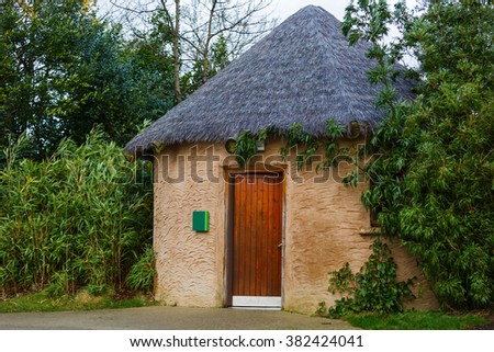 Photo of small rustic hut between trees