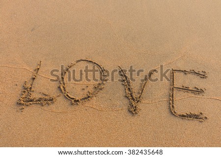 The word love written on the sand background