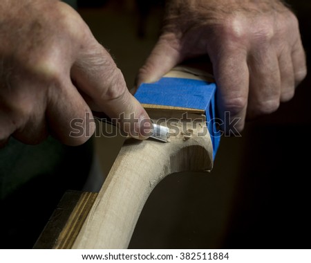 Craftsman using a Chisel to Shape the Neck of a Cello - Low Key