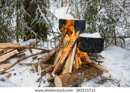 Tourist on fire in black cauldrons melted snow for cooking dinner. 