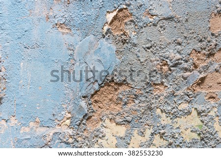 Close-up view a weathered, rough and dirty concrete wall with cracked stucco layer. Rustic blue grunge material from old wall seamless texture in an ancient town of Vietnam.