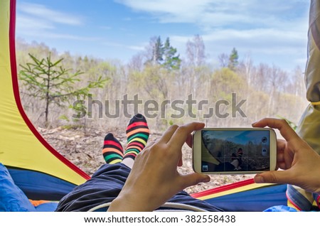 Relaxing woman in tent. Tourism. Takes piktures