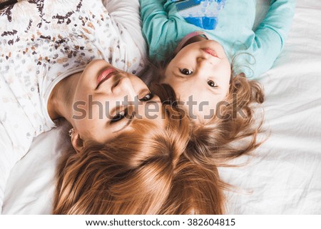 mom and daughter having fun in bed the morning