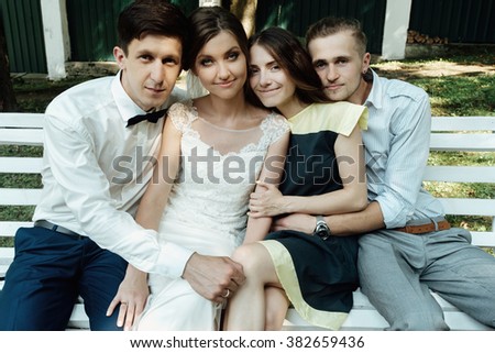 stylish gorgeous happy bride and groom having photo with friends at wedding reception