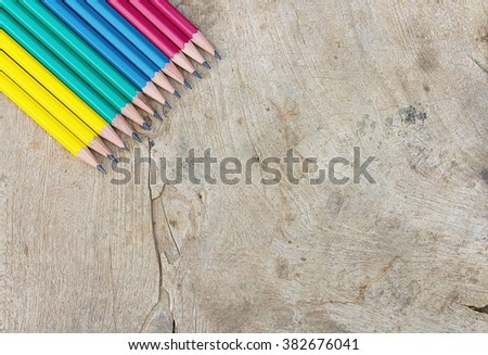 Wooden table with pencils, top view