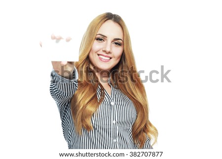 A beautiful woman holds out a business card. Smiling and pointing to it.