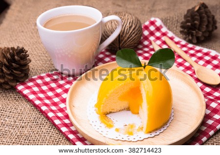 Orange cake with orange form and coffee cup
