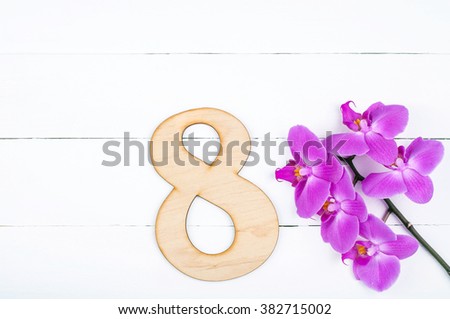8 March International Women's Day background with copy space. 8 march greeting card with blooming orchid flowers on white wooden table. Rustic style