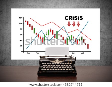 Vintage typewriter on table and drawing crisis chart on placard