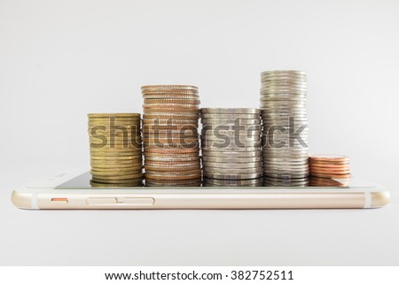 stack of coins on smart phone  isolated on white background - business finance concept