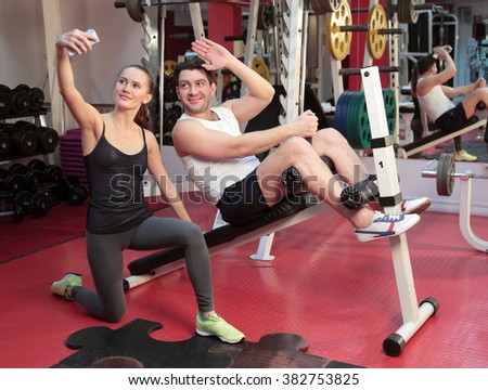 A girl and a guy are in the gym and take pictures
