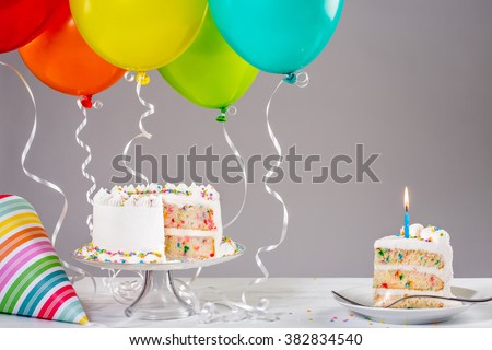 White birthday cake with colorful balloons Royalty-Free Stock Photo #382834540