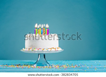 White birthday cake over blue background Royalty-Free Stock Photo #382834705