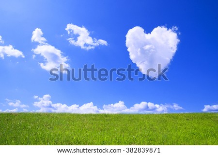 Picture of a a heart cloud on blue sky and green field