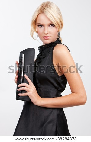 Portrait of a young woman in black dress over grey background