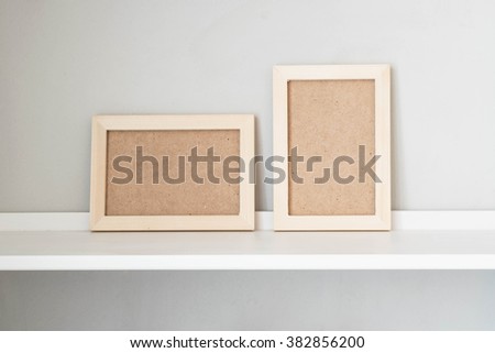 Wooden picture frame on the white shelf; Horizontal and vertical picture frame 
