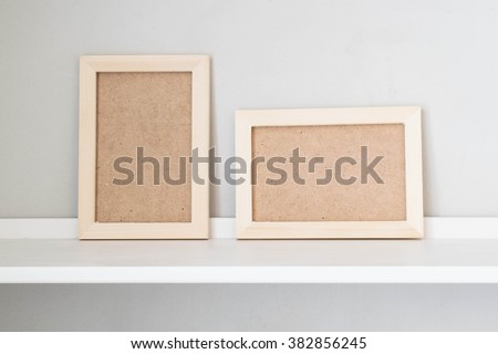 Wooden picture frame on the white shelf; Vertical and horizontal picture frame 