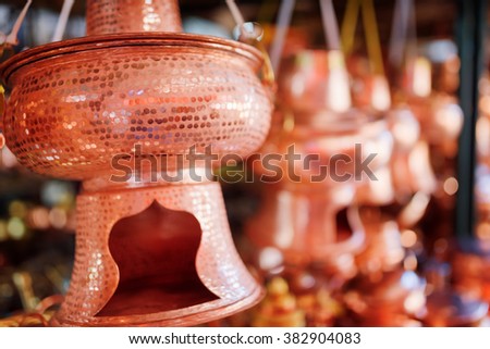 Vintage copper hot pot (steamboat) at market, the Old Town of Lijiang, Yunnan province, China. Traditional Chinese handmade utensils are visible in background. Shallow depth of field.