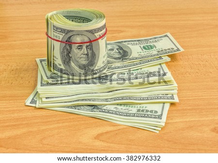 US hundred dollar bills on wooden table, selective focus. 