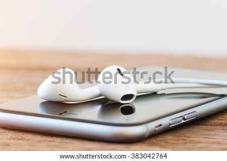 closeup phone and headphone device on table