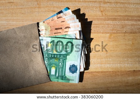 Euro banknotes in salary brown envelope.