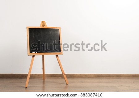 Wooden painter tripod easel on white wall