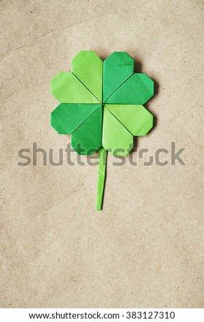 Green origami paper shamrock clover leaf on eco paper background. St. Patrick's Day greeting postcard template. Space for copy, text, lettering.