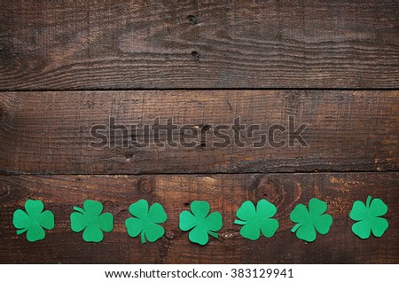 Paper green clover shamrock leaf border on dark wooden background. Space for copy, text, lettering.
