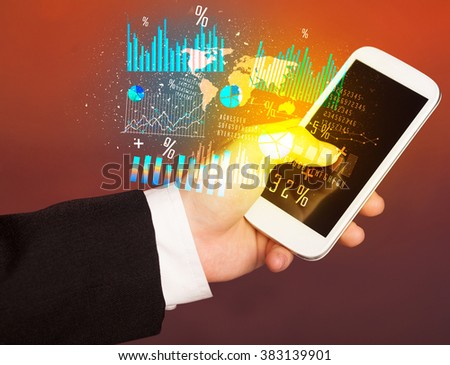 Hand holding smartphone with business diagrams on it