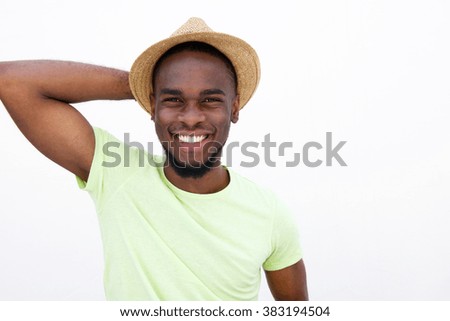 Close up portrait of a cool young man wearing hat against white background with hand behind head