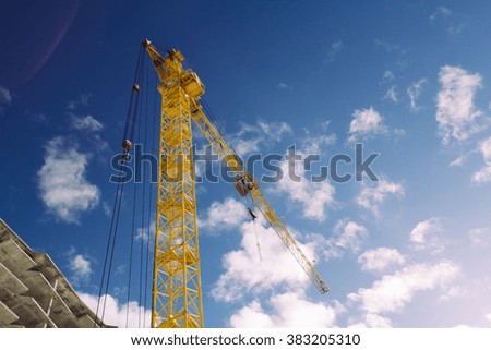 the construction crane and the building against the blue sky