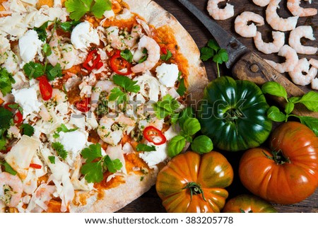 A hand stretched,wood fired pizza base topped with tomato and fresh basil,mozzarella cheese ,garlic king prawns,red chilli and coriander.