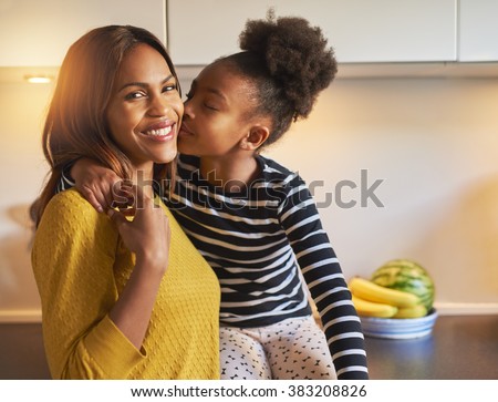 Black mom and daughter loving each other woman smiling at camera Royalty-Free Stock Photo #383208826