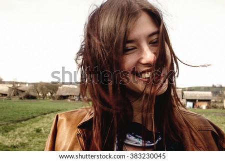 stylish beautiful brunette girl walking and smilling outdoors in spring portrait
