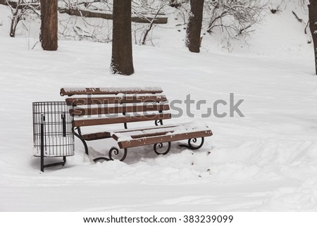 single bench covered with snow in winter park