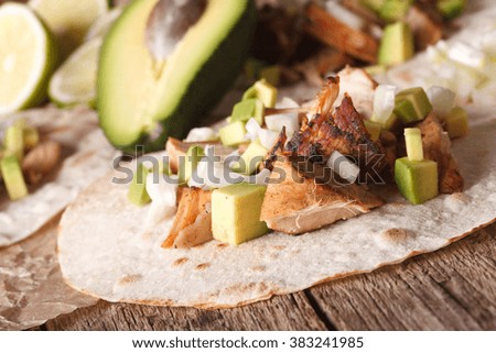 Carnitas Pork with onion and avocado on tortilla close-up on the table. horizontal
