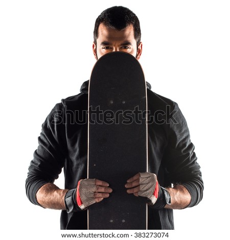 Man hiding behind his skateboard 