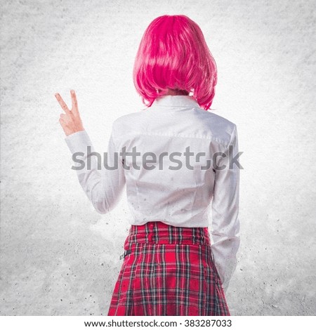 Girl with pink hair doing victory gesture