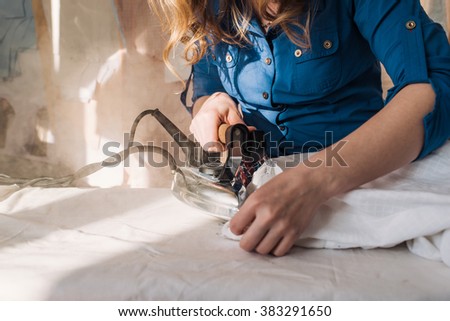 dressmaker stroked the fabric with steam iron
