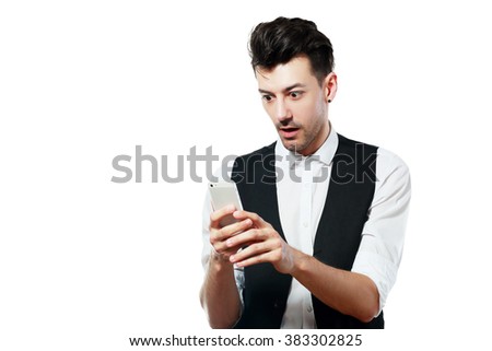 Shocked news! Studio portrait of amazed young man using smartphone. Isolated on white.