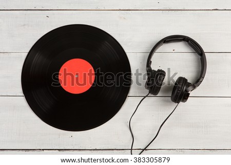 Vintage record LP and headphones on the wooden background